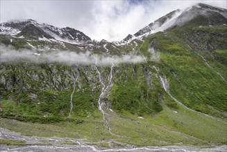 Mountain streams flow over steep mountain slopes into the tagl of the Schlegeisgrund, cloudy rocky
