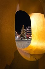 View through an illuminated ring onto a Christmas tree at night, Nagold, Black Forest, Germany,