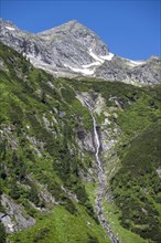 Waterfall of a mountain stream Kesselbach, rocky mountain peak, Berliner Hoehenweg, Zillertal Alps,