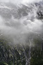 Cloudy mountain landscape, mountain streams as waterfalls on a mountain slope, Furtschaglhaus,