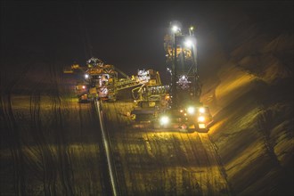 Mining machinery at night with intensive lighting during work, open-cast lignite mine, North
