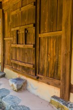 Oriental wooden door that slides to open and close on old stucco building