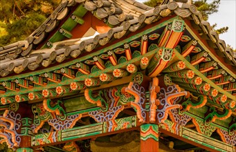 Closeup of oriental building with ceramic tiled roof and colorful designs