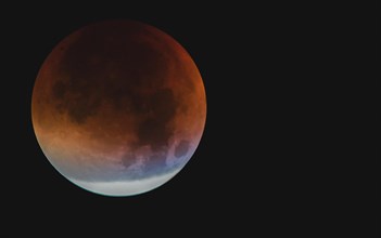 A moon with visible orange and blue tones during a partial lunar eclipse, Haan, North