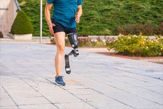 Lower part of a runner with prosthetic leg running along a park