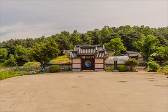 Daejeon, South Korea, May 22, 2018: Korean woman sitting under tree in front of stone wall attached