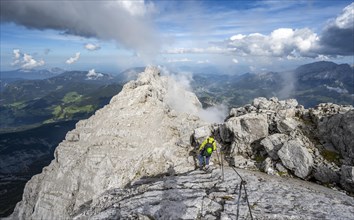 Climber on a via ferrata secured with steel rope, narrow rocky ridge, Watzmann crossing to Watzmann