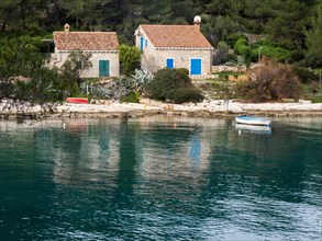 View from the promenade path to a small house by the sea, near Veli Losinj, Kvarner Bay, Croatia,