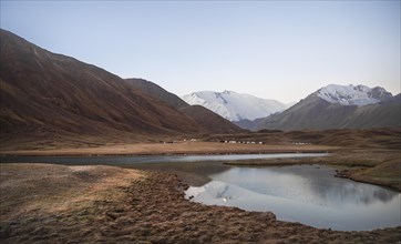 Yurts, mountains reflected in a small mountain lake, Pik Lenin, Trans Alay Mountains, Pamir
