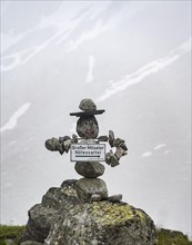 Figure made of stones with a face, signpost to the Grosser Moeseler summit, mountaineer on a hiking