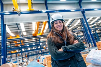 Portrait of a young and proud woman standing in a logistic center