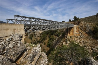 Steel bridge spans a rocky gorge under a blue sky, Aradena Gorge, Aradena, Sfakia, Crete, Greece,