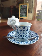 An elegant porcelain cup and saucer in a nostalgic vintage themed cafe, autumnal aesthetic