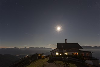 Mountain hut at full moon in front of mountains, at night, illuminated, Wankhaus, view of Karwendel