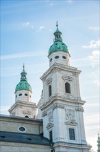 Sky rises behind two prominent church towers with detailed architecture, Salzburg, Austria, Europe