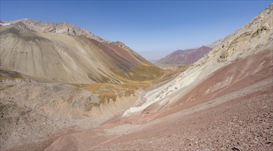 Mountain landscape of glacial moraines, mountains with red and yellow rocks, Traveller's Pass below