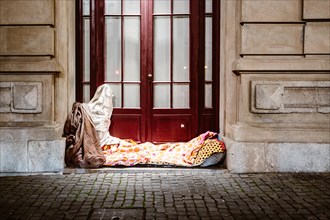Illuminated bed of homeless person in front of urban house, Porto, Portugal, Europe