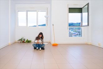 Mother and child sitting in the middle of an empty house after moving