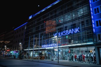 Modern bank branch with illuminated glass facade in a nocturnal urban scene, Volksbankhaus,