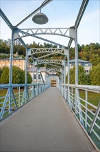 Pedestrian bridge with blue steel construction and clear sky in the background, Mozartsteg