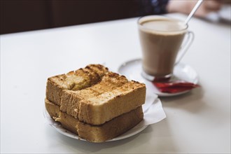 Traditional Portuguese breakfast, toasted loaf bread with butter and coffee, Portugal, Europe
