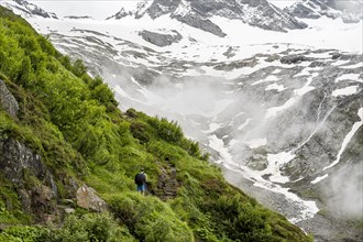 Mountaineers on a hiking trail, Schlegeiskees glacier in the background, cloudy and atmospheric