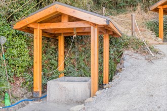 Water well under wooded pavilion beside hiking trail in mountain park