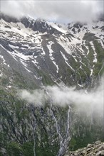 Snow-covered cloudy mountains, mountain streams as waterfalls on a mountain slope, Furtschaglhaus,