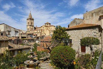 Panoramic view of old roofs and church towers of a small town with green vegetation, Novara di