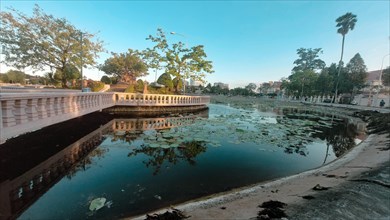 A serene urban pond called Srah Chhouk or Lotus Pond in the middle of Kampot town with reflected