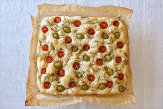 Homemade Italian flatbread Focaccia with cherry tomatoes, olives and rosemary