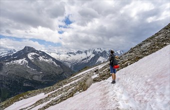 Mountaineer on hiking trail with snow, Berliner Hoehenweg, mountain landscape with glaciated peaks