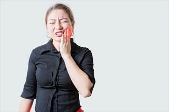 Young woman suffering with toothache isolated. Unhappy girl rubbing cheek with toothache