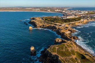 Aerial image of peninsula and town of Peniche, Portugal on sunny day. Summer sunset haze, little