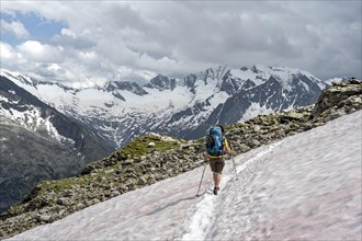 Mountaineer on hiking trail with snow, Berliner Hoehenweg, mountain landscape with glaciated peaks