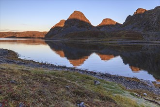 Reflection of Bergen in the fjord at morning light, autumn, Nordkinn Peninsula, Finnmark, Norway,