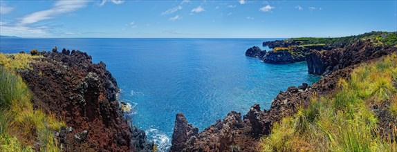 Panoramic view of a rugged coastal landscape with volcanic cliffs and sweeping sea views, lava