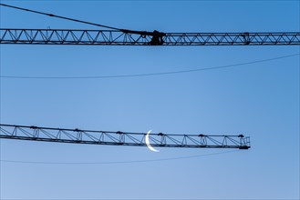 Crescent moon, in front of a construction crane, Germany, Europe