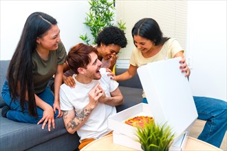 Happy and hungry young multi-ethnic friends receiving a delivery pizza
