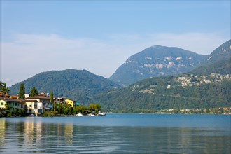 Waterfront in City of Riva San Vitale with Mountain View on Lake Lugano in a Sunny Summer Day in