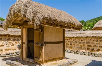 Buyeo, South Korea, July 7, 2018: Traditional outhouse with straw thatch roof and wooden door