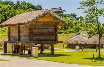 Buyeo, South Korea, July 7, 2018:Large log building with straw thatch roof elevated off ground in