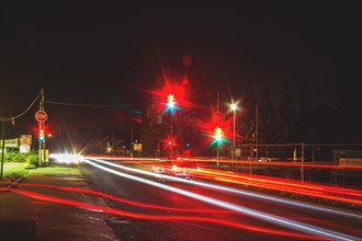 Long exposure of a road junction at night with red traffic lights and light trails from cars, Haan,