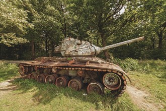 An old, rusty tank surrounded by green vegetation in the forest, M47 Patton, Lost Place, Brander