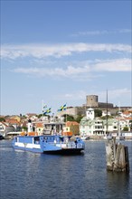 Ferry in the harbour of the archipelago island Marstrandsoe, behind the fortress Carlsten,