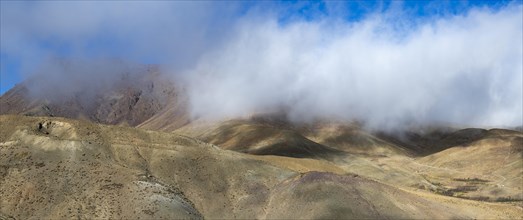 Low hanging clouds in the mountain landscape at the Tizi-n-Tichka pass road, High Atlas, Morocco,