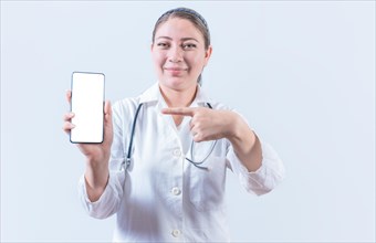 Beautiful female doctor holding and pointing at phone screen. Young female doctor showing and
