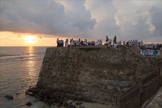 School group on fort ramparts at sunset in historic town of Galle, Sri Lanka, Asia