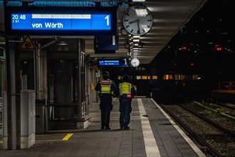 Station employees on an illuminated platform during the evening hours, Pforzheim, Germany, Europe