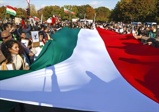 Iranians demonstrate in Berlin with a large Iranian flag to support the protests in Iran. The